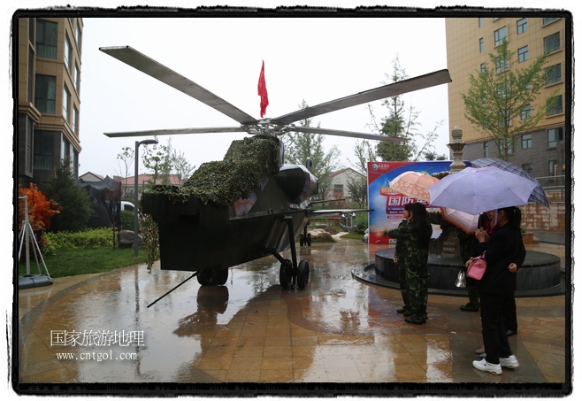 小區(qū)突然出現(xiàn)“飛機(jī)坦克”，其中殲15艦載戰(zhàn)斗機(jī)一架、99式主戰(zhàn)坦克一輛、武直-10武裝直升機(jī)一架，吸引了眾多市民雨中圍觀、合影。